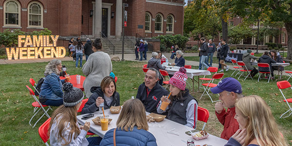 Miami families gather at tables for a picnic in front of Alumni Hall during Family Weekend