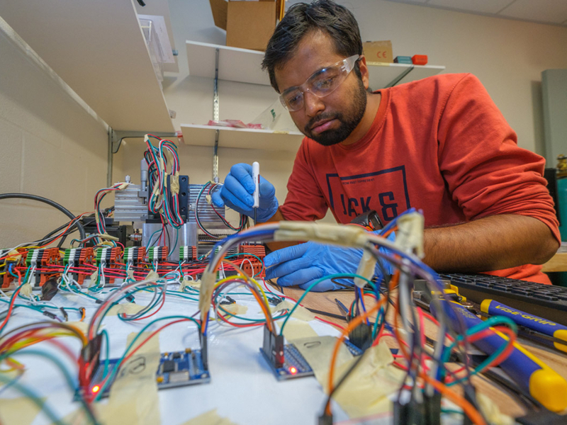 A student working on electrical wiring in the lab.