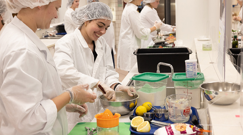 Nutrition in Disease Prevention management students cooking in the kitchen lab