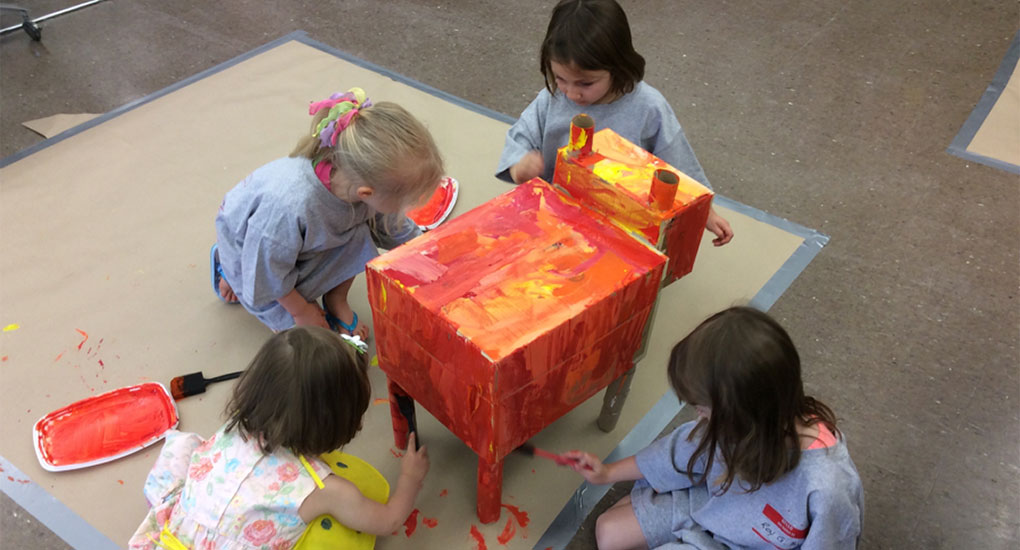 elementary students painting a table
