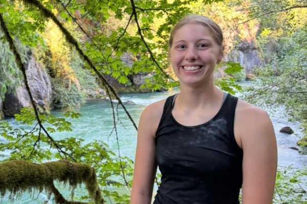 Henlie Krause standing in the trees with a river behind her.