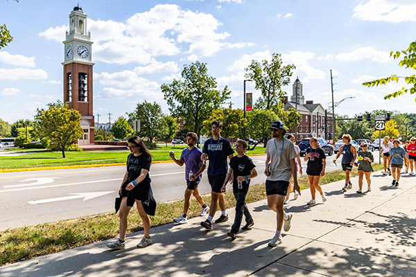 a line of people walking on a sidewalk for suicide prevention