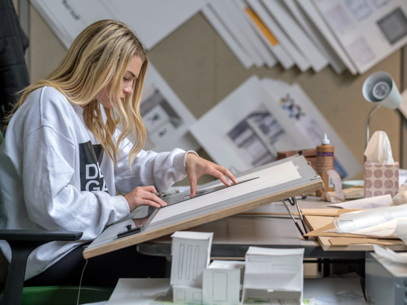 Graphic Design student working at the drawing table.