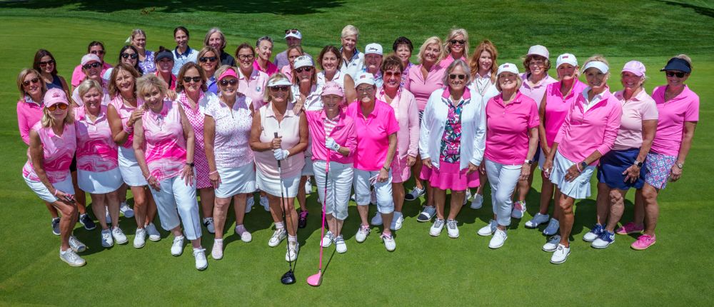 group of women golfers all wearing pink and white