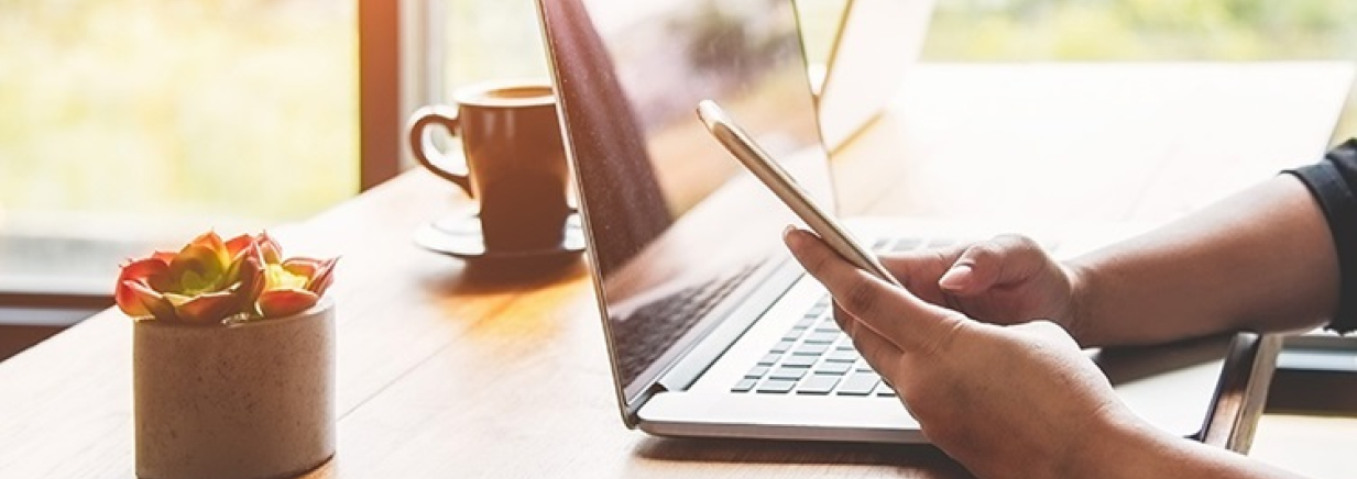 Person using smartphone and laptop computer