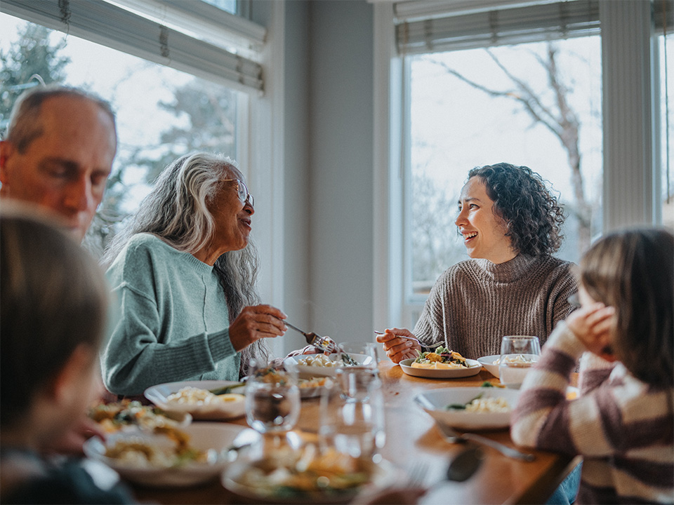 Family gathered around a dining table sharing a meal and conversation during flu season.
