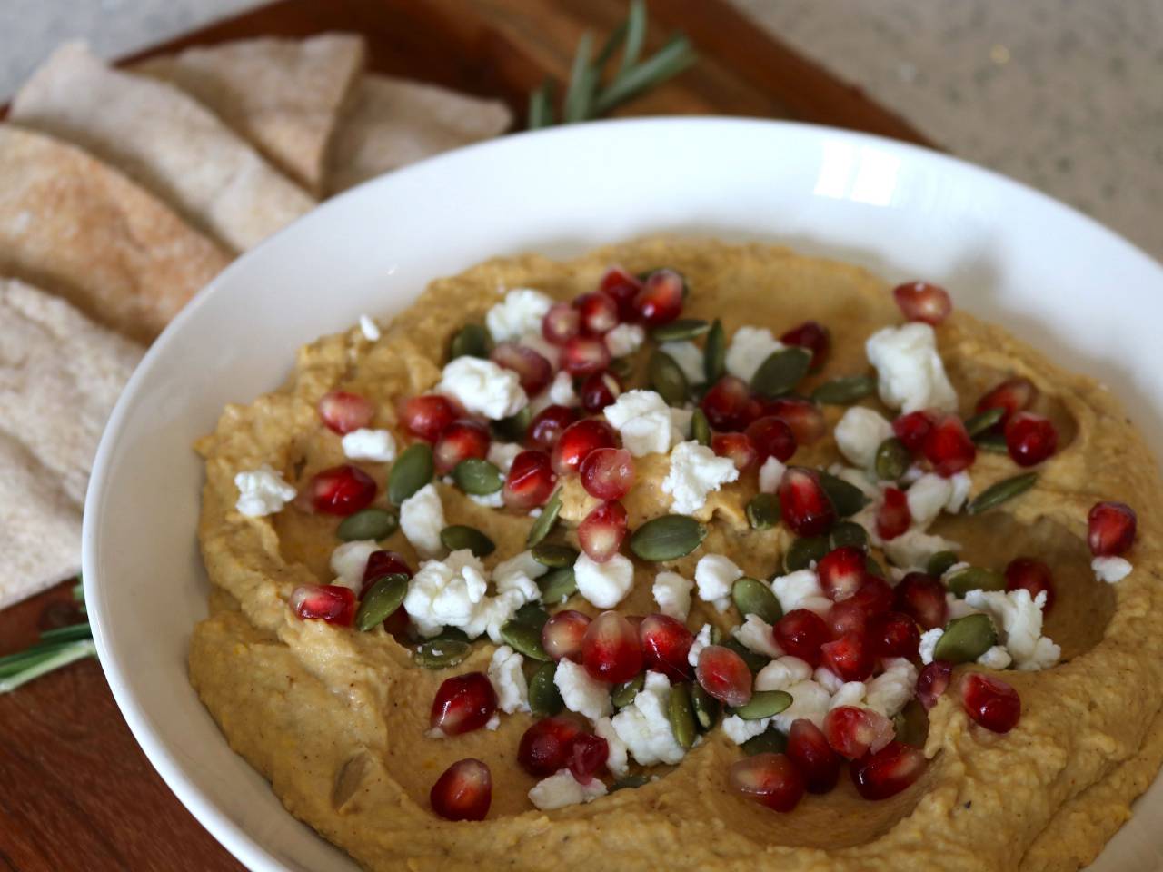 Photo of a white bowl filled with butternut squash hummus