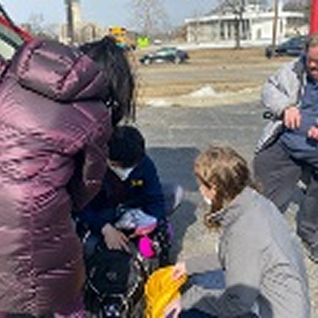 A diverse group of individuals loading a van with bags of food, showcasing community support and engagement in local initiatives.