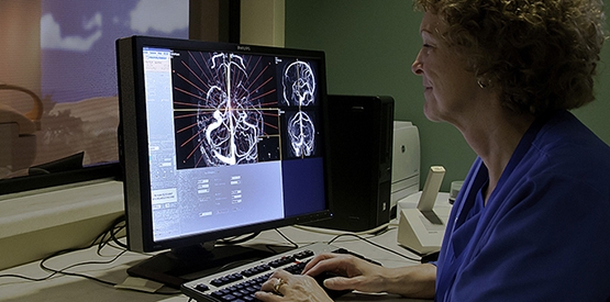 Radiology doctor reviewing scan on computer