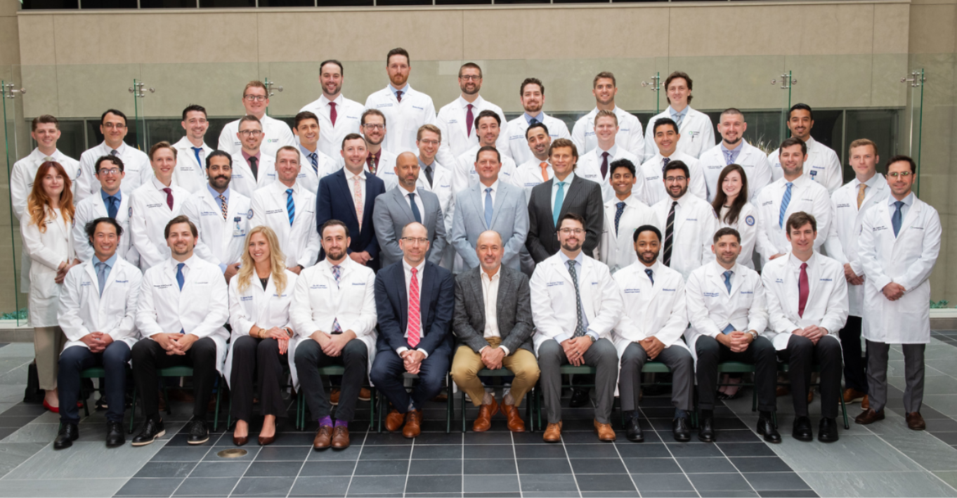 Group of staff and residents dressed up and in white coats posing for a group picture.