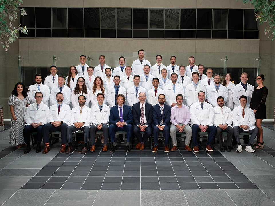 Group of staff and residents dressed up and in white coats posing for a group picture.