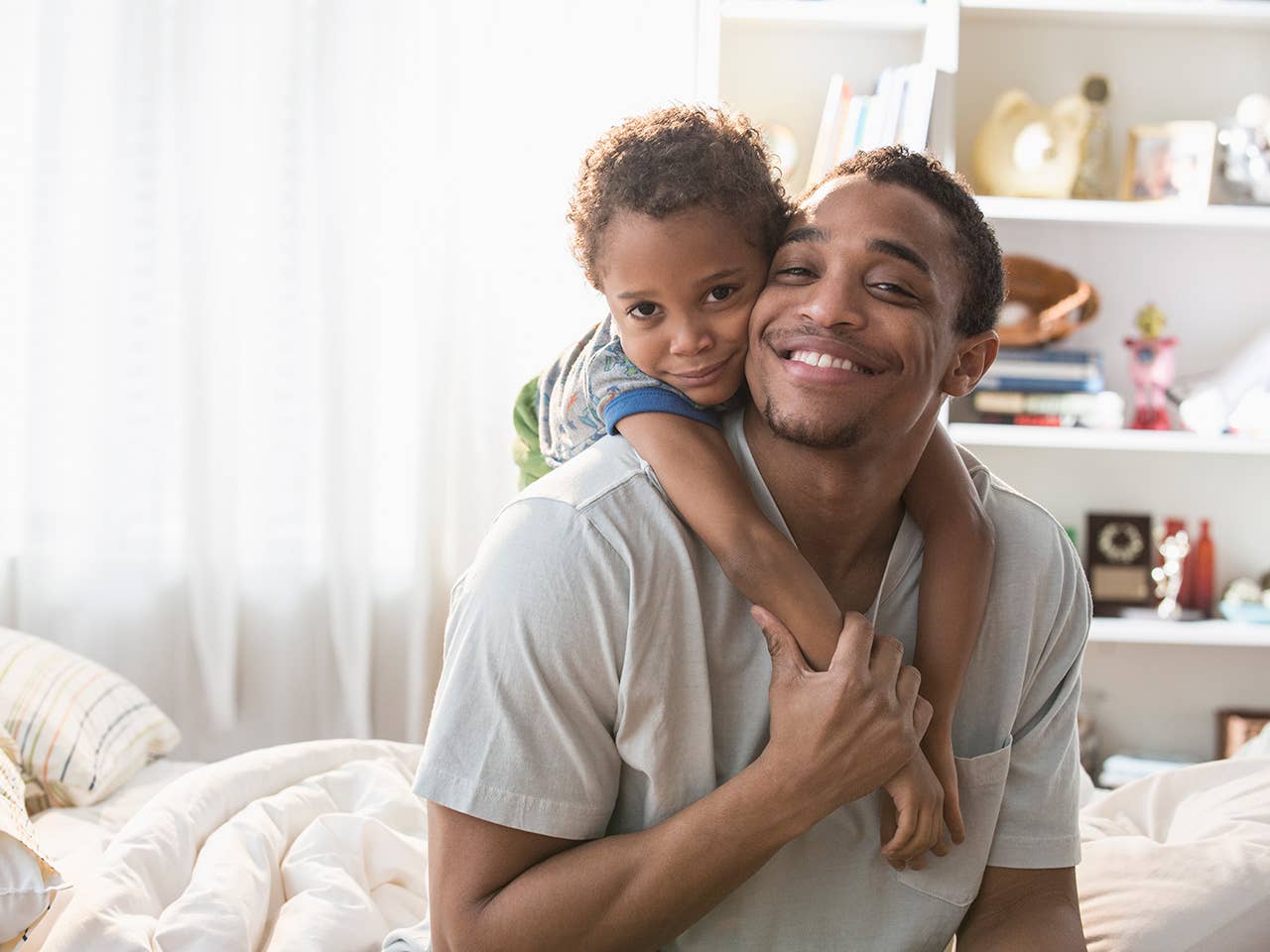 Father and his young child at home smiling.