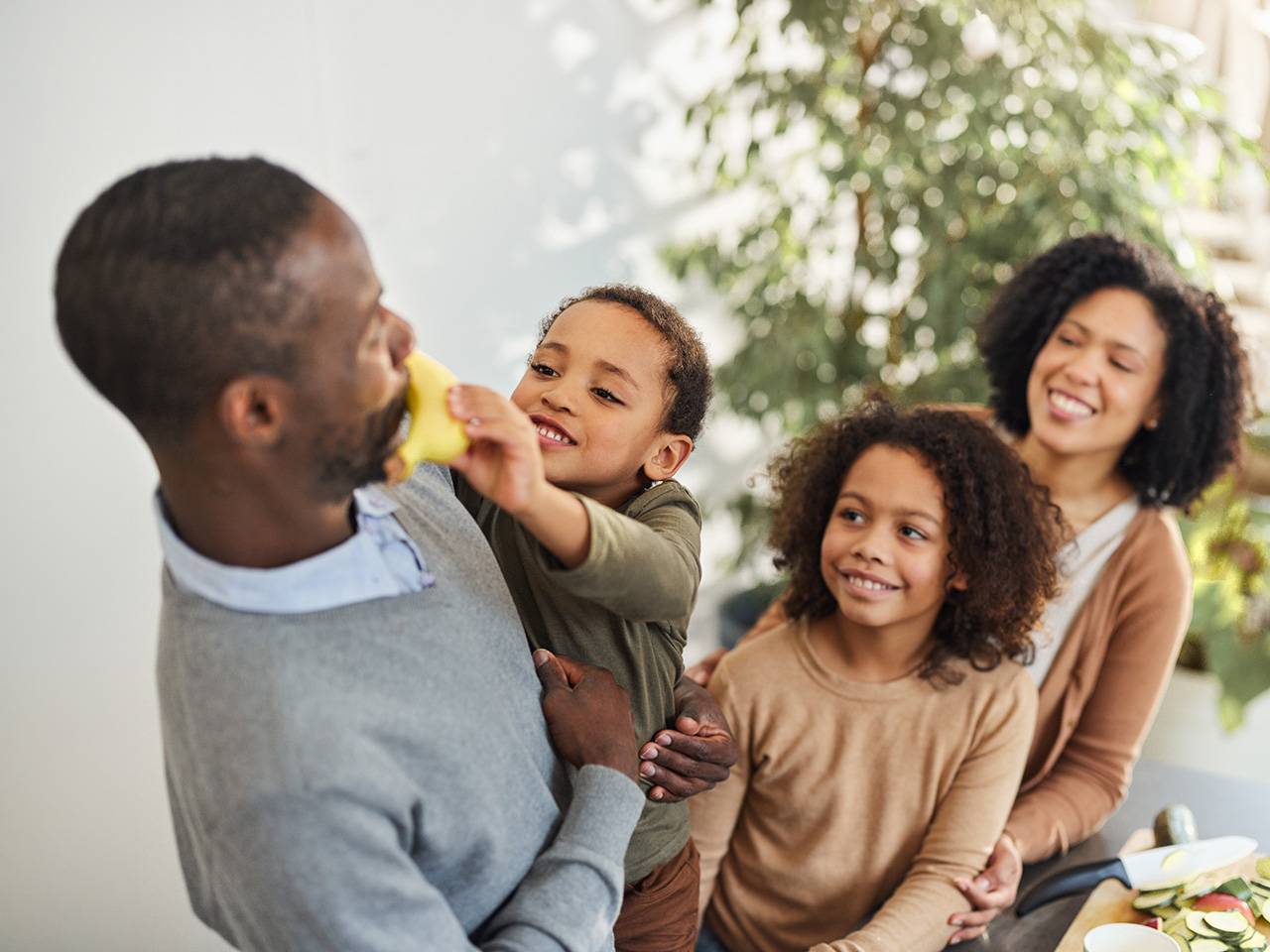 Family sharing fresh fruit and healthy foods at home, building nutritious eating habits together