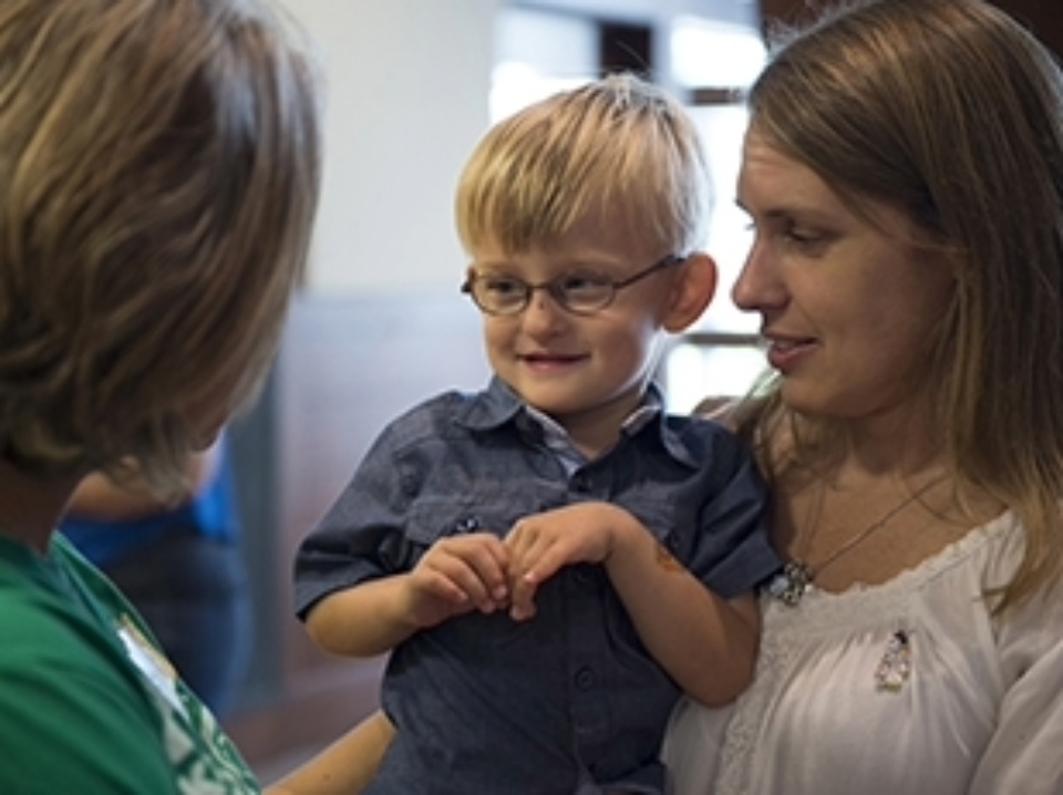 Boy and mother talking to a staff member in the neonatal intensive care unit