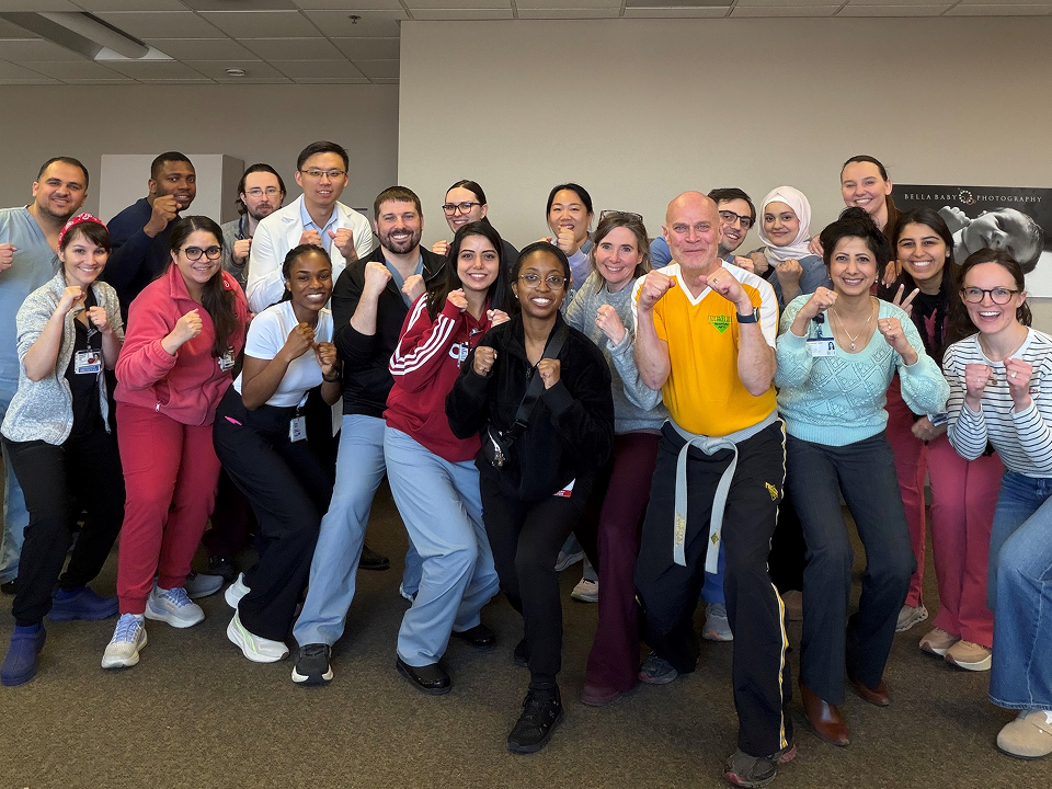 Group of medical residents and staff posing with raised boxing stances during a wellness or team-building event.