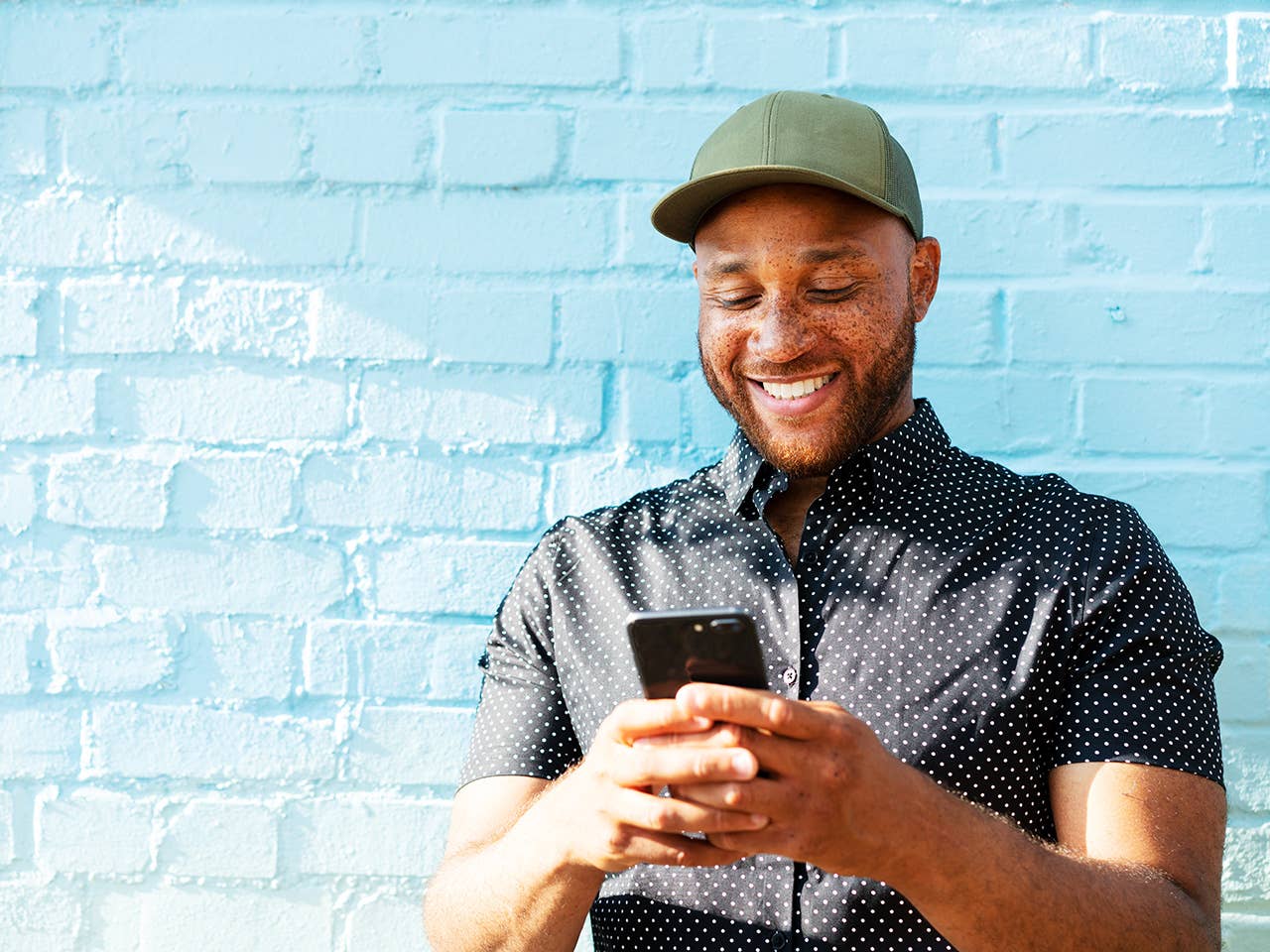 Smiling Black man uses his phone to fill out the Corewell Health primary care quiz