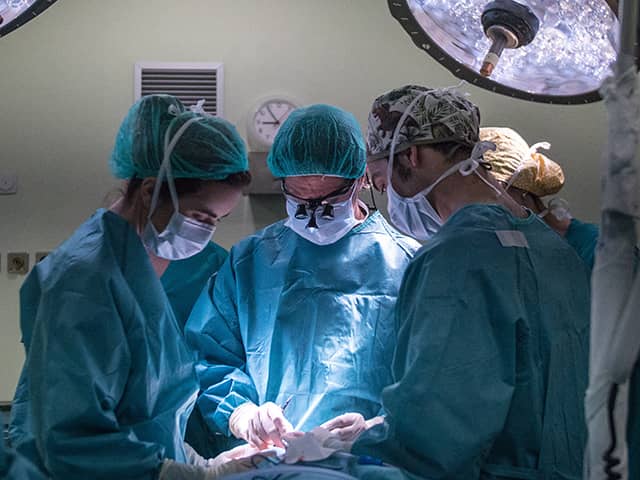 Group of surgery team members and surgeons performing surgery in operating room