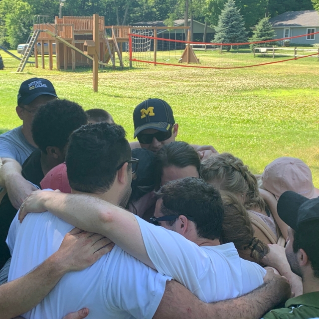 Residents in a group hug at an outdoor group training event