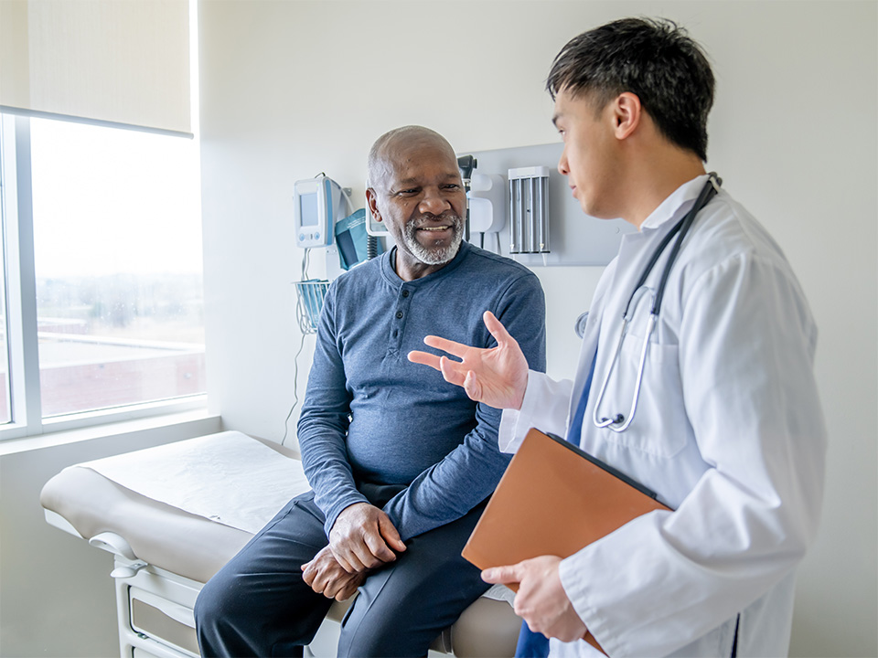 Patient consulting with a doctor about shoulder pain treatment during a medical exam in a healthcare clinic.