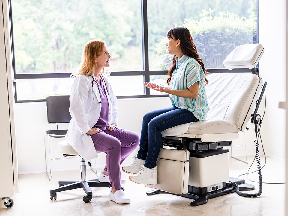 Patient discussing hip pain symptoms and treatment options with a doctor during a medical exam in a clinic.