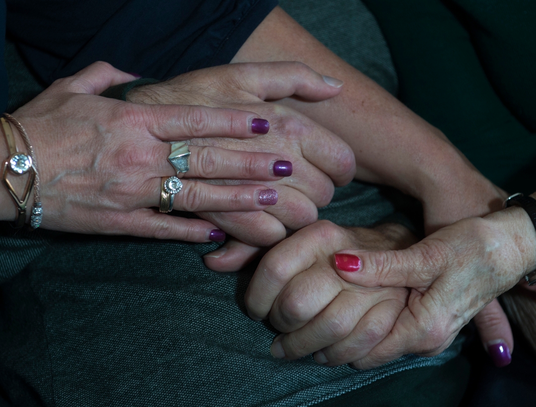 people holding hands with a hospice patient 