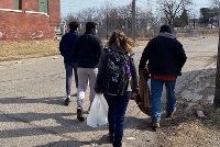 A diverse group of individuals walking together on a city street, symbolizing community engagement and unity.