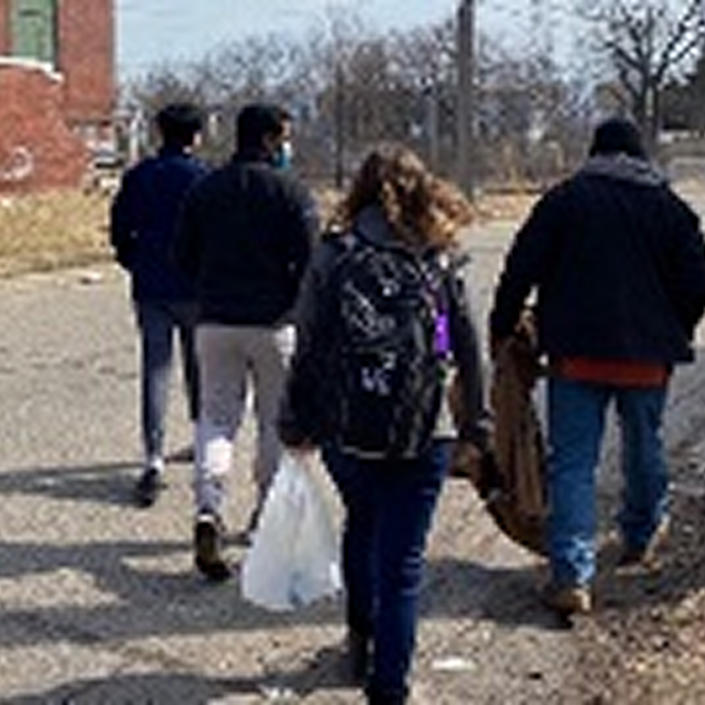 A diverse group of individuals walking together on a city street, symbolizing community engagement and unity.