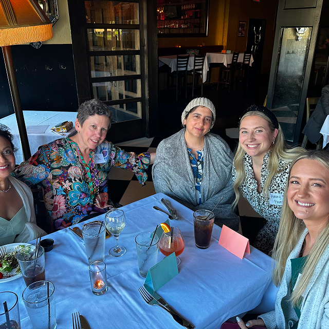 Attendees seated together around a restaurant table during a residency celebration dinner