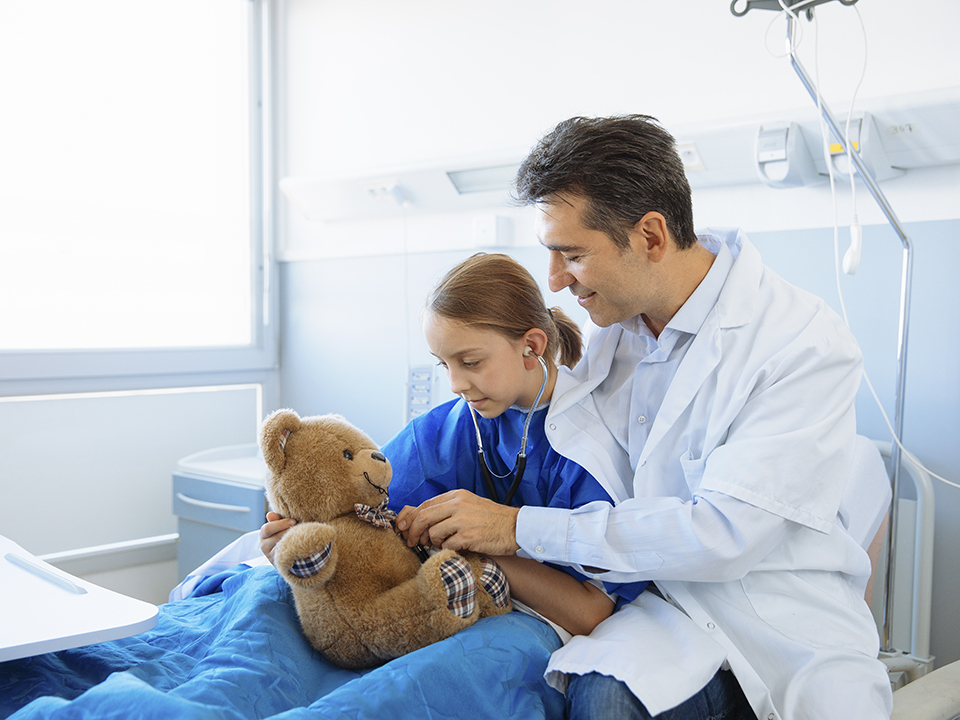 A man and a girl are seated in a hospital bed, conveying a sense of comfort and companionship in a health care setting.