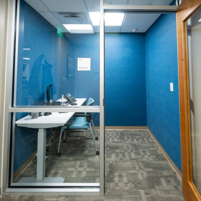 Private workspace with table, phone and computer with a door