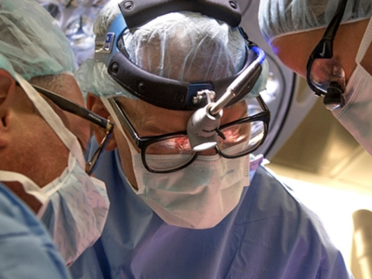 Three surgeons looking over their patient