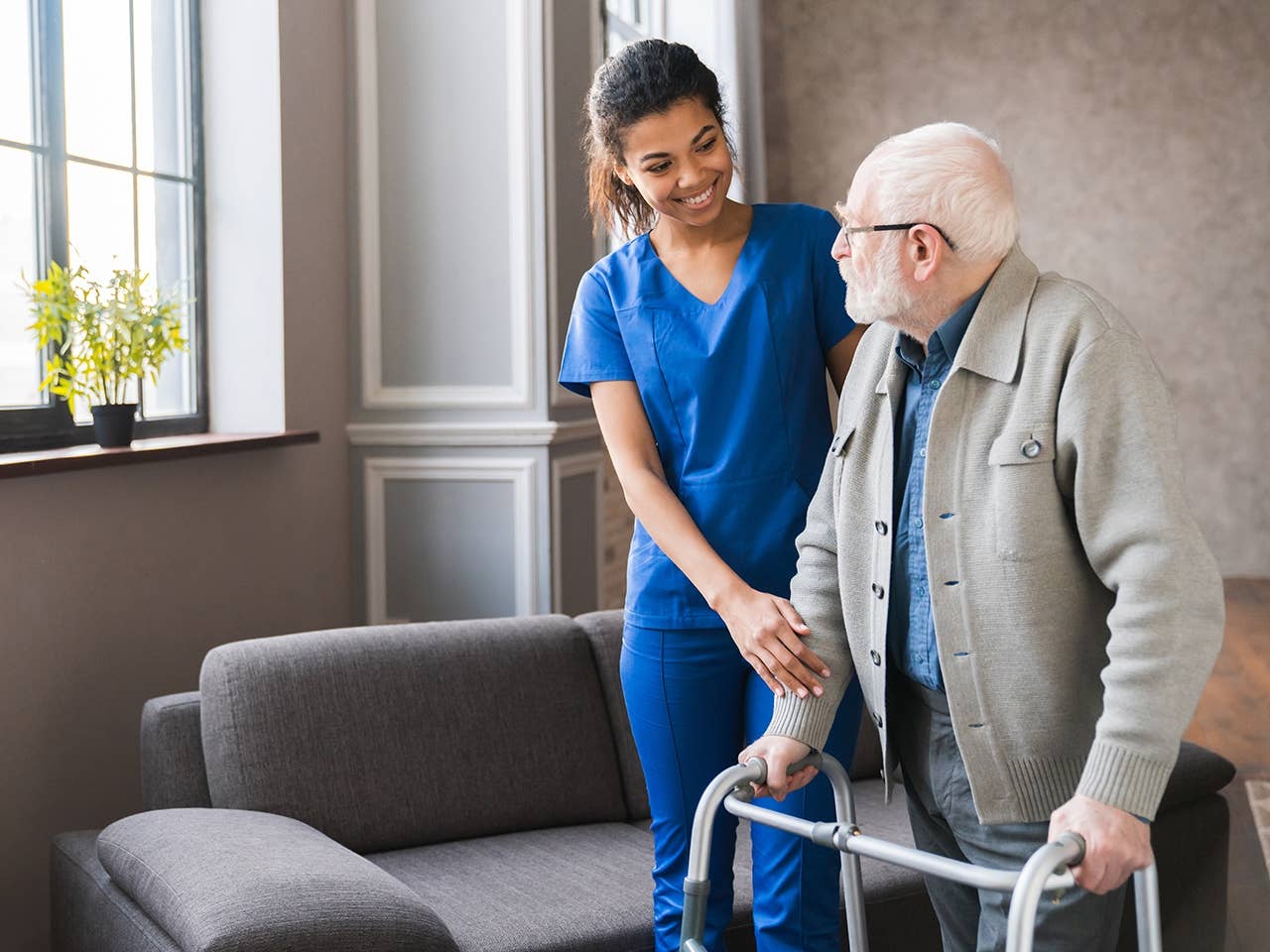 female nurse helping an elderly man with a walker