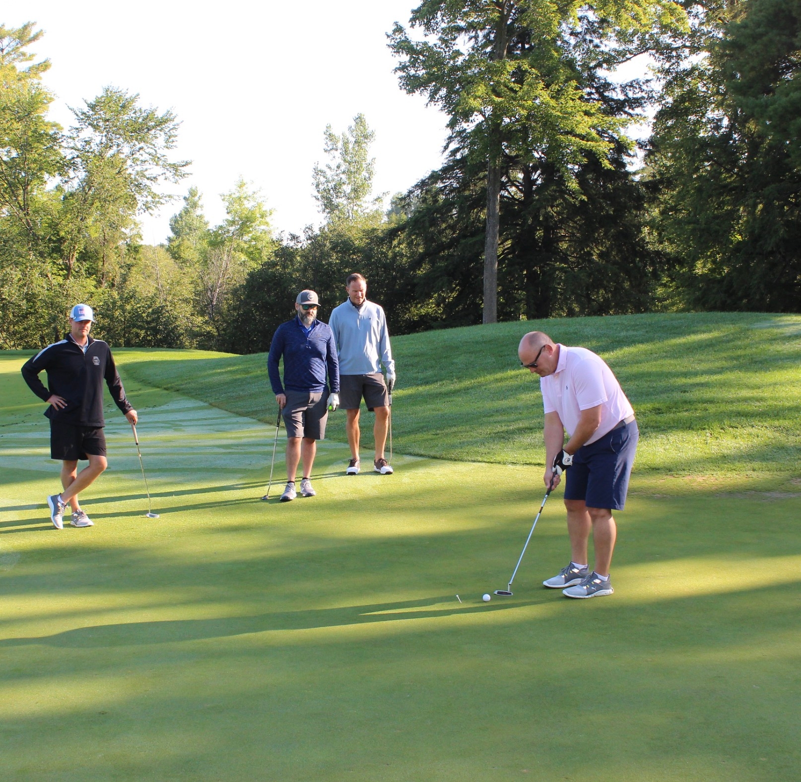 Three people golfing at the golf event