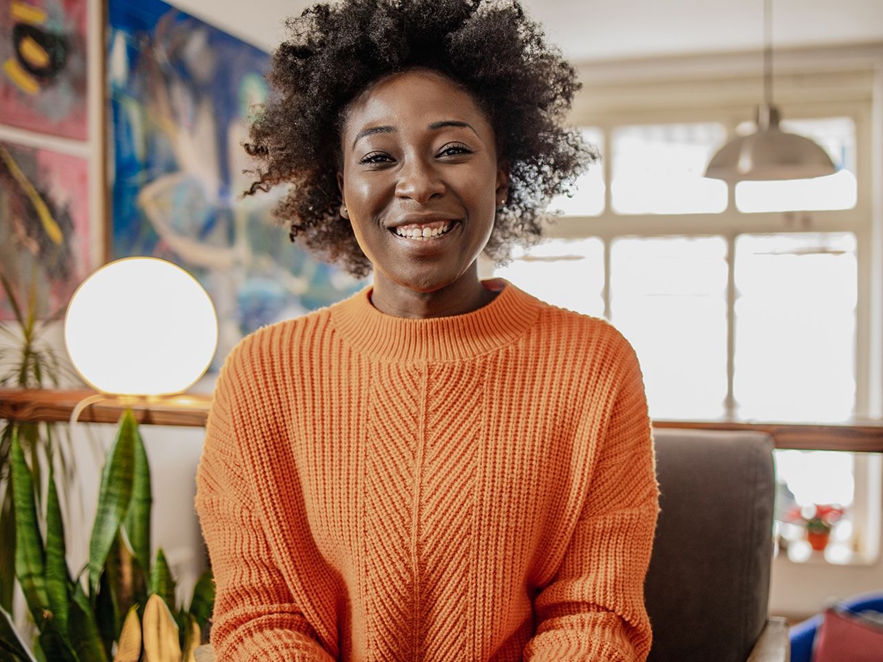 Smiling Black woman in an orange shirt