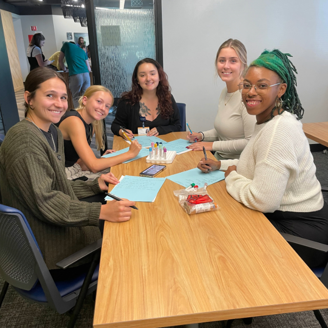 Group of students sitting around a table working on something