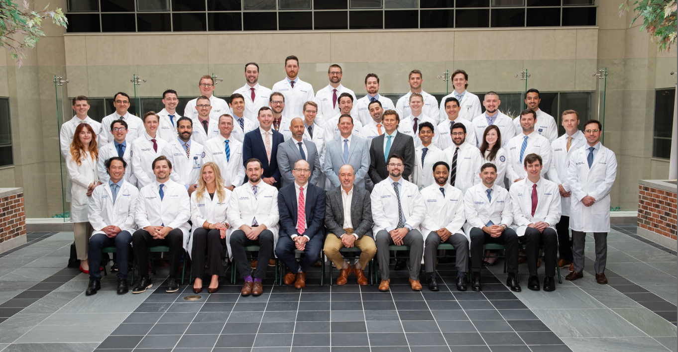 Group of staff and residents dressed up and in white coats posing for a group picture.
