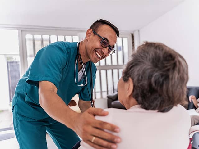 A doctor converses with an elderly woman in a medical office, discussing her health and treatment options.