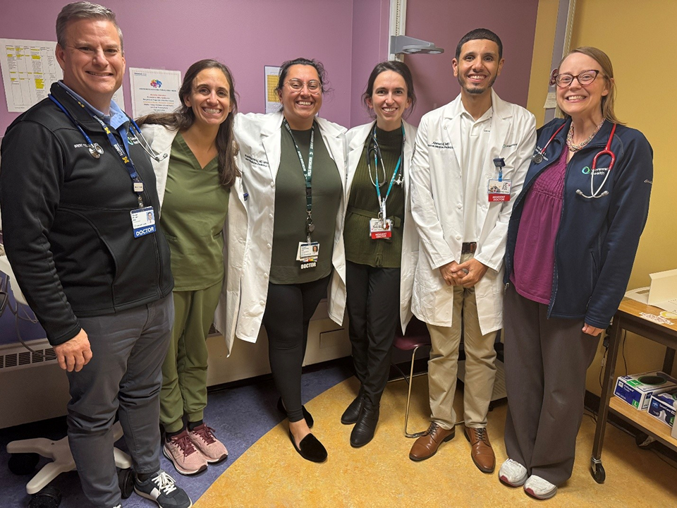 Internal Medicine and Pediatrics residents and faculty posing together in a clinic setting.