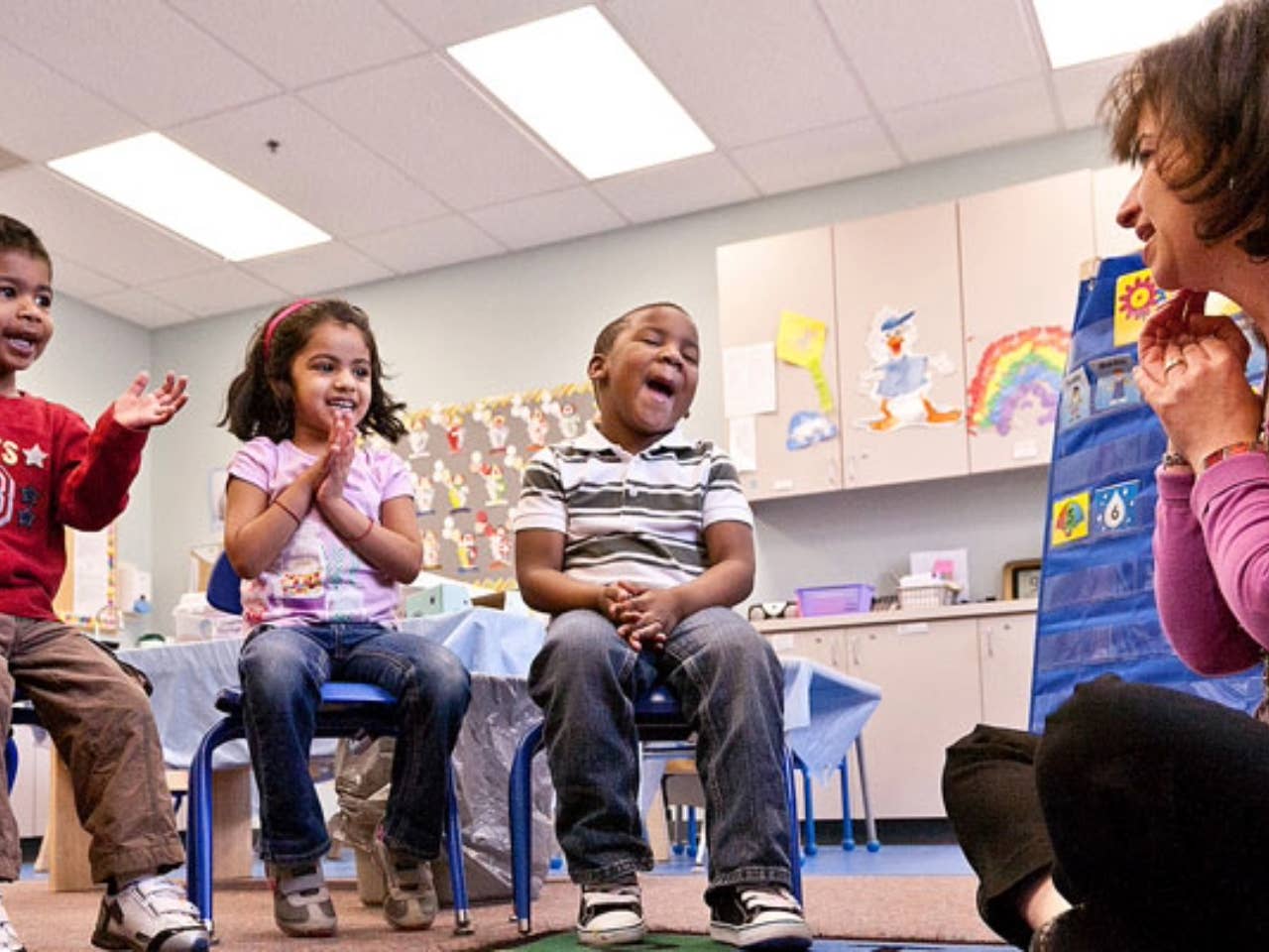 Female working with group of young children.