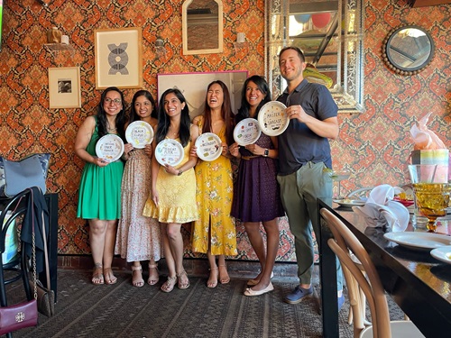 A group of individuals joyfully posing for a photo, surrounded by colorful balloons, celebrating wellness and camaraderie.