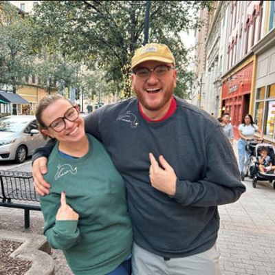 White woman on left and white man on right hug and smile