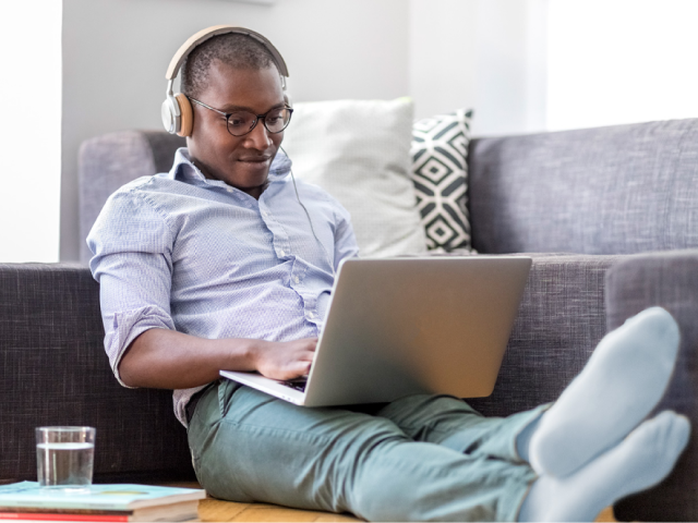 Man sitting on couch working on his laptop