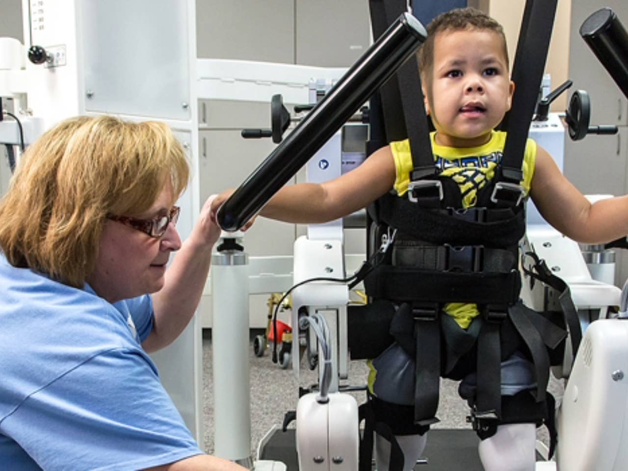 Little boy working through exercises at rehab facility with a medical professional.