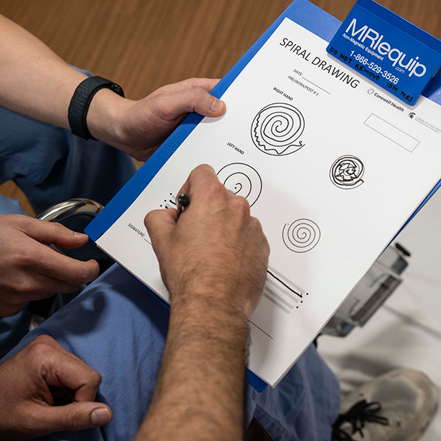 A man holds a clipboard displaying a detailed diagram, focused on the information presented.
