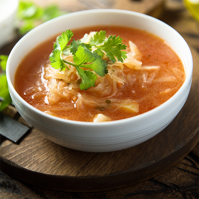 Bowl of unstuffed cabbage soup topped with fresh herbs, featuring cabbage in a hearty homemade meal.