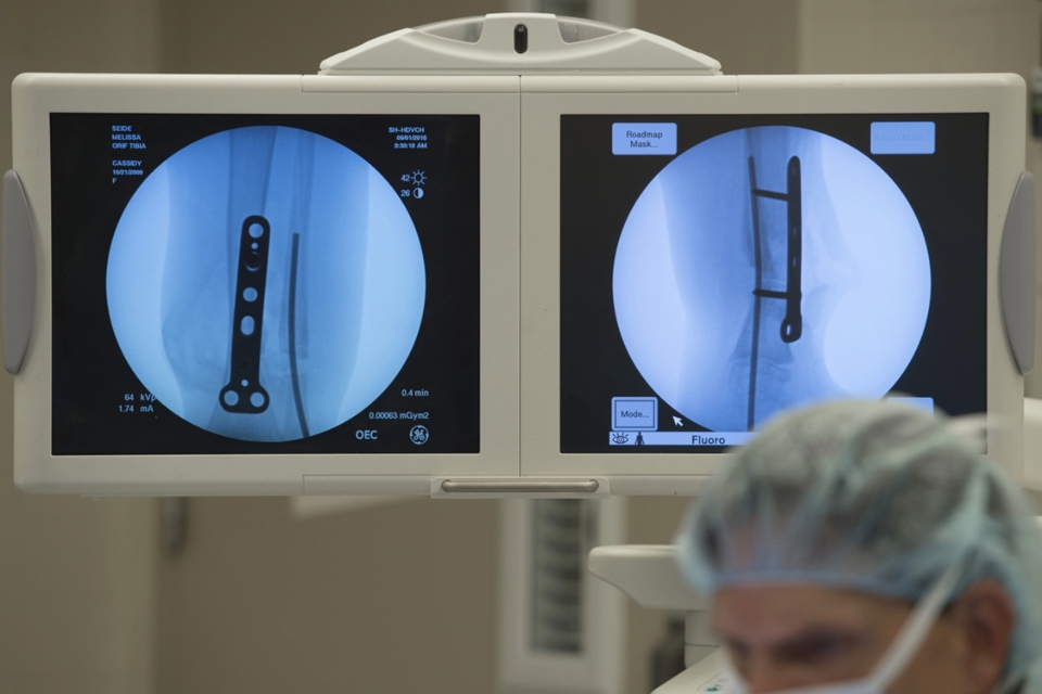 Surgeon in an operating room with X-rays behind them