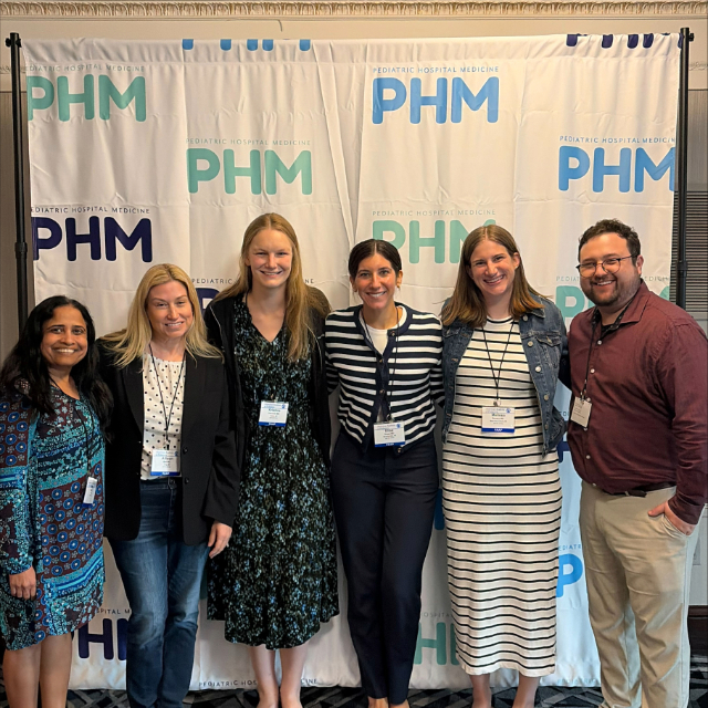 group of people posing for a photo together at a pediatric hospital medicine event