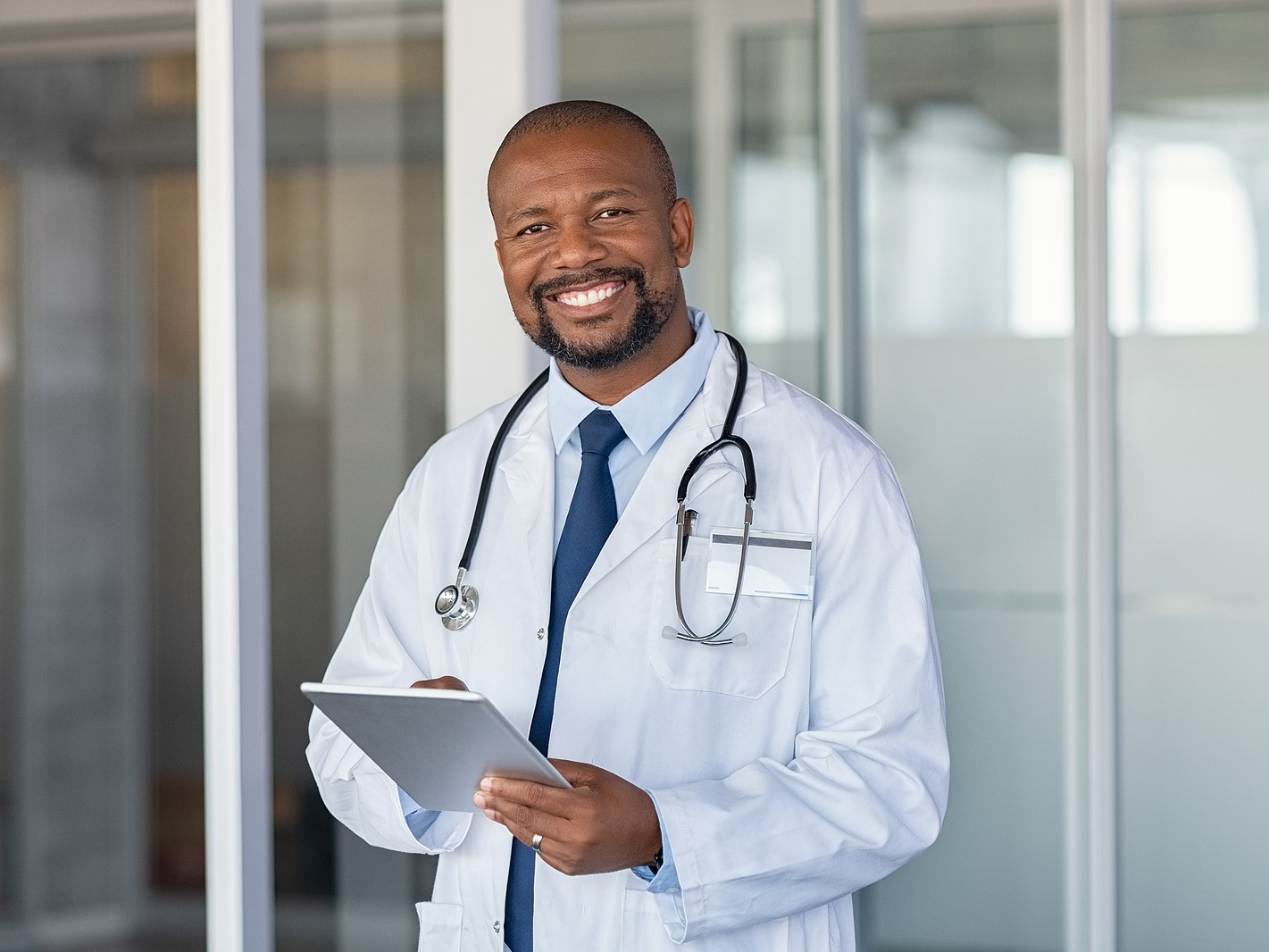 Physician smiling with tablet in hand