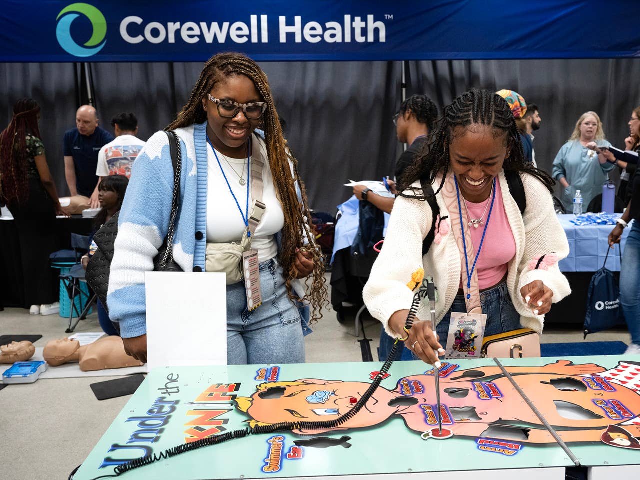 Two women standing at a table playing a game.