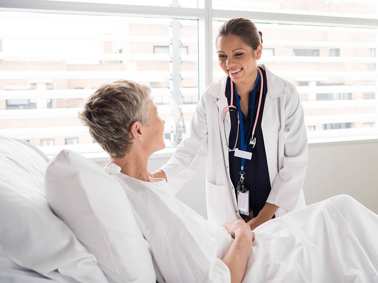 Female doctor talking to a female patient in her hospital bed